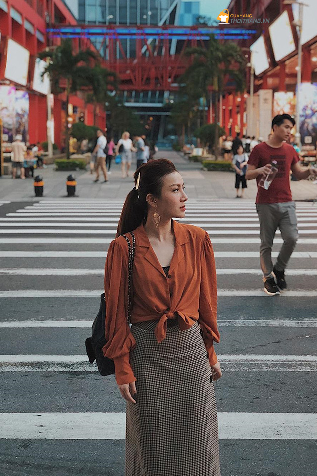 Ca sĩ Yến Nhi thể hiện phong cách tinh tế, thanh lịch trong dáng áo sơ mi buộc vạt kết hợp cùng chân váy bút chì kẻ sọc