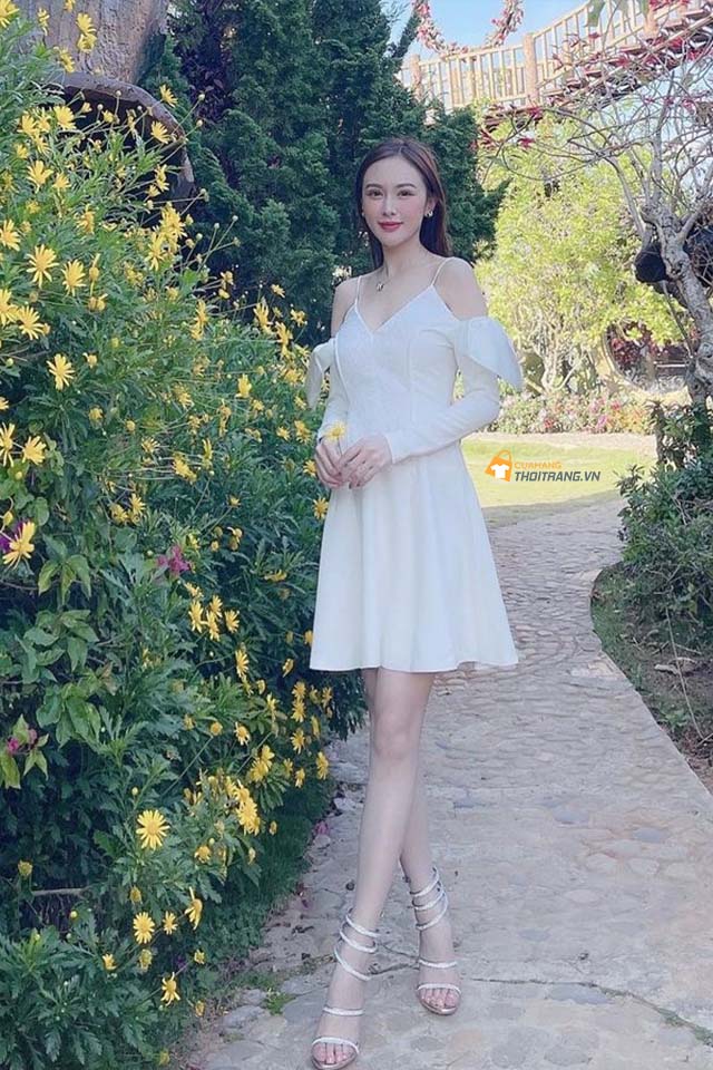 Kelly ''thả dáng'' trong chiếc đầm trắng xẻ vai, phối cùng sandals đan dây yểu điệu.