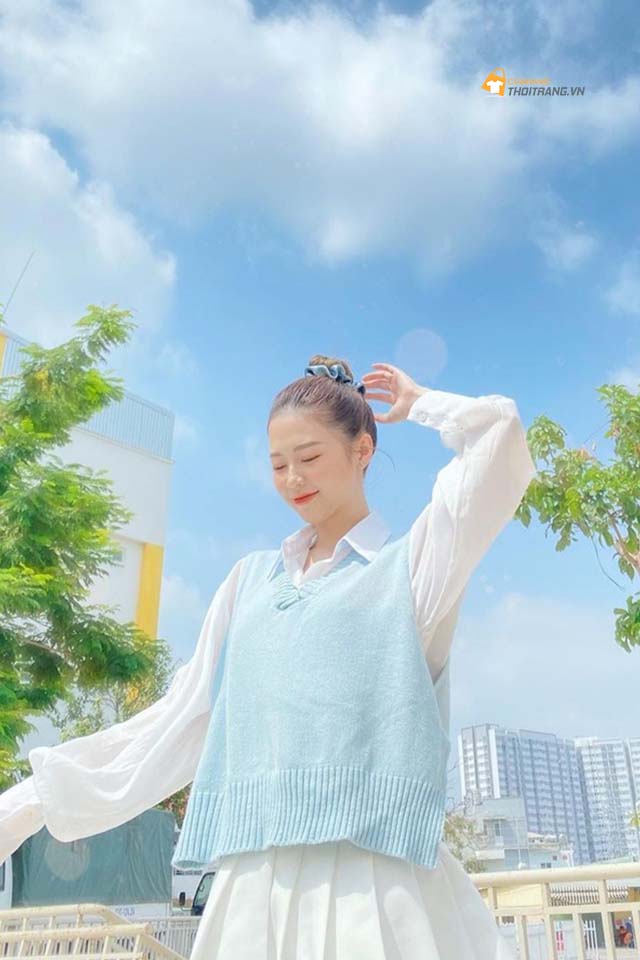 Liz Kim Cương ''ăn gian'' tuổi với set đồ đậm cảm hứng preppy. Cô nàng hóa nữ sinh nhờ layer áo sơmi trắng và gilê len màu phấn